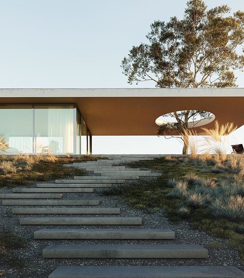 Casa contemporánea elevada sobre una ladera ajardinada.